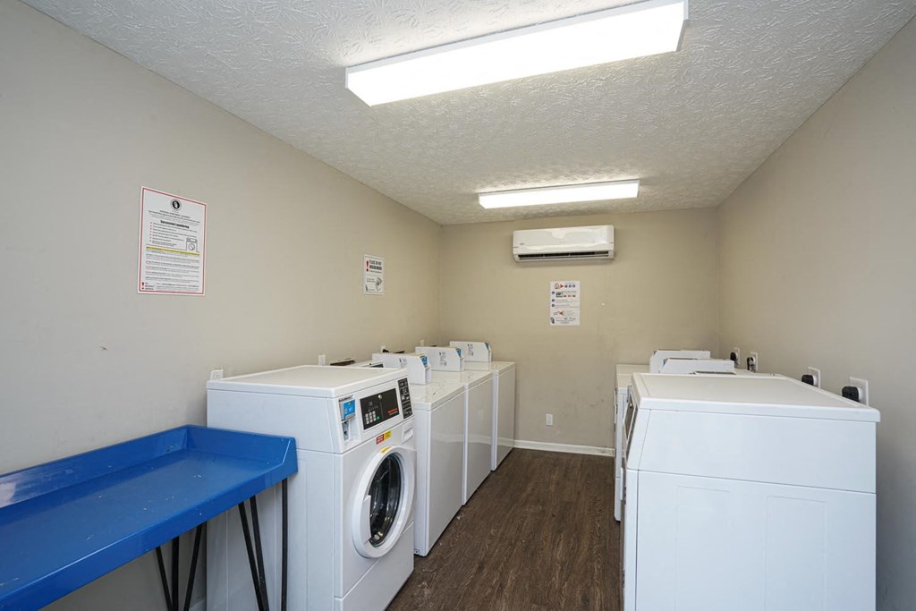 a laundry room with four washes and two dryers in it