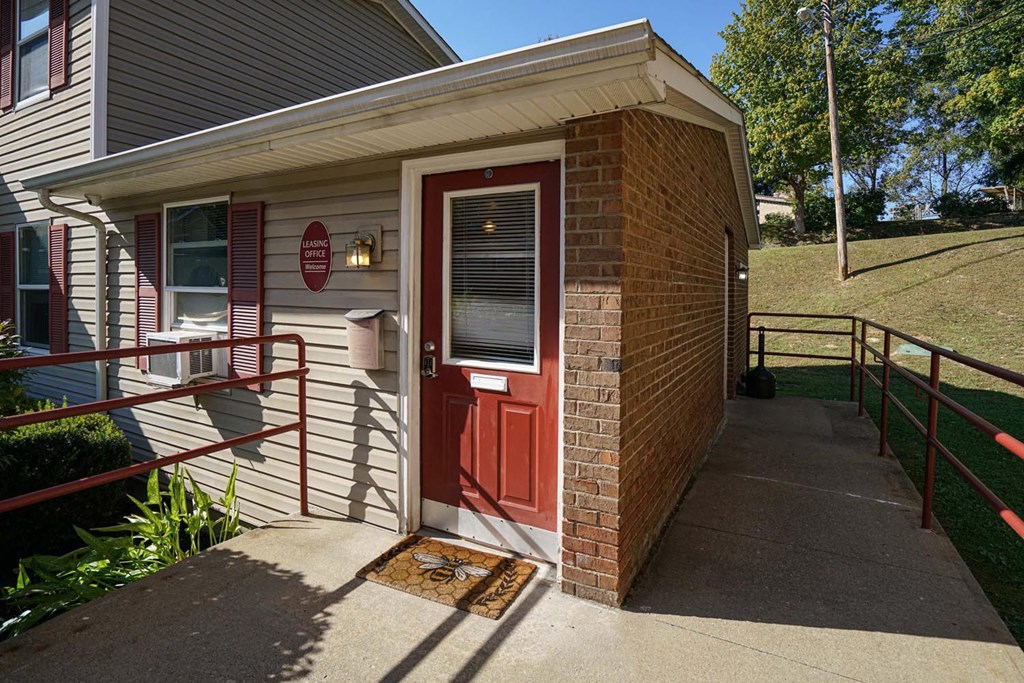 the front porch of a house with a red door