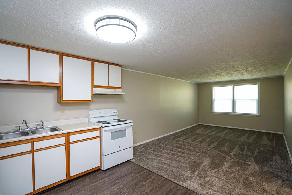 an empty kitchen with white appliances and white cabinets