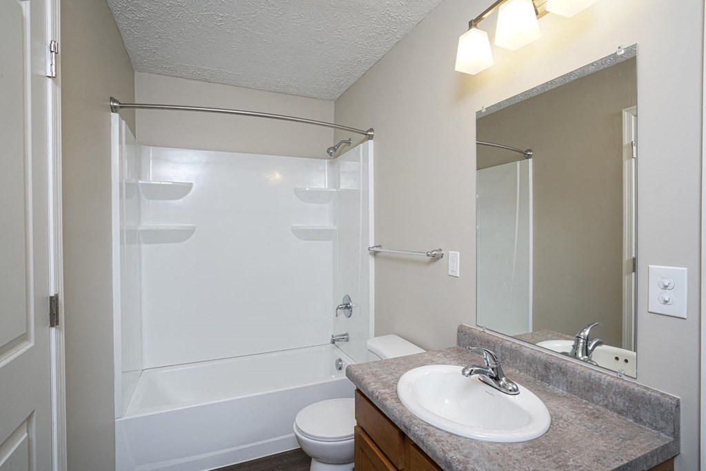a bathroom with a sink and a shower and a toilet