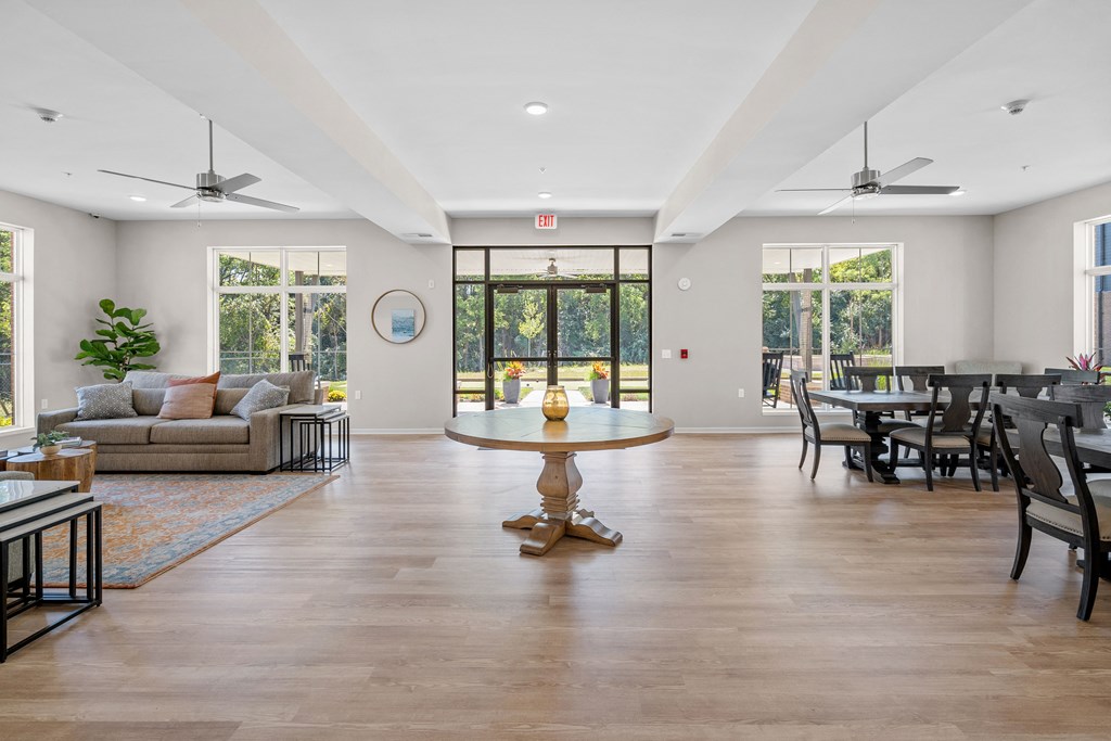 the living room and dining room of a house with white walls and wood flooring