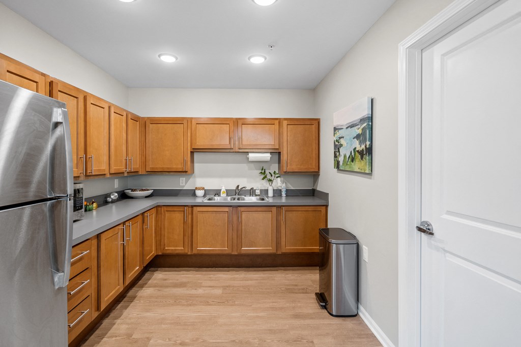 a kitchen with wooden cabinets and a stainless steel refrigerator