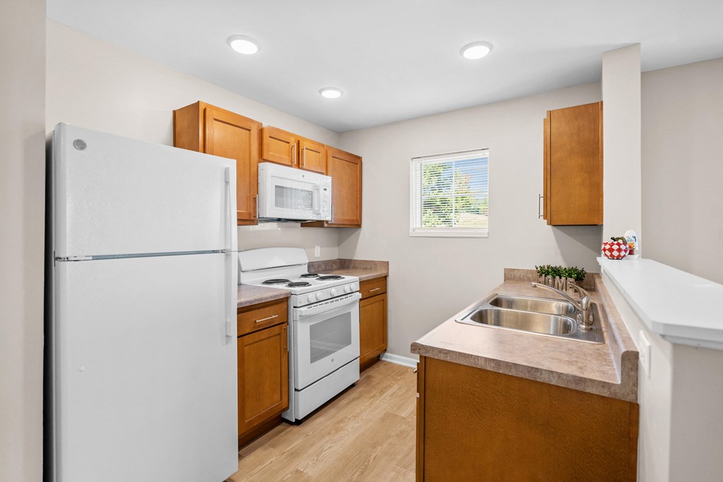a kitchen with white appliances and wooden cabinets