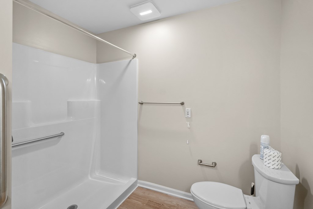 a white bathroom with a shower and a toilet