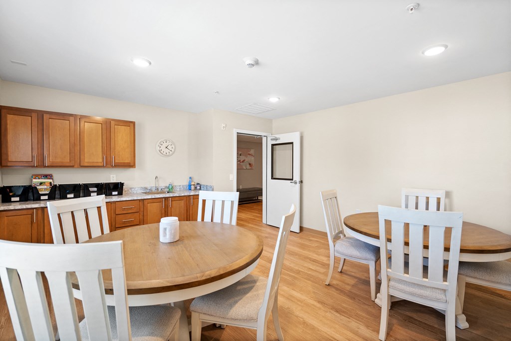 a dining room and kitchen with a wooden table and chairs