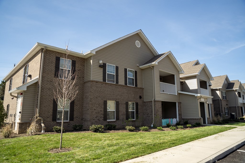 a brick house with a sidewalk in front of it