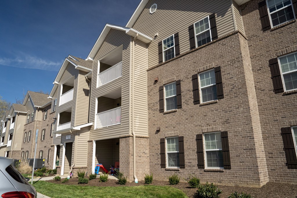 a brick apartment building with a car parked in front of it