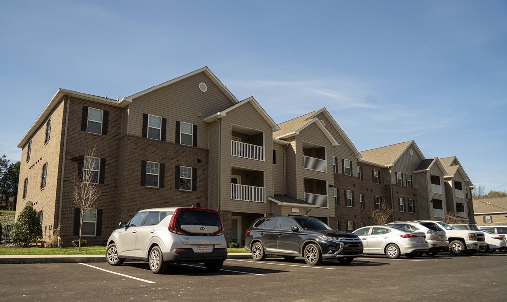 a parking lot with cars in front of an apartment building