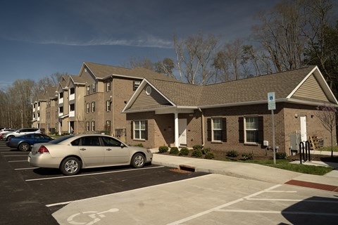 a car parked in a parking lot in front of an apartment building