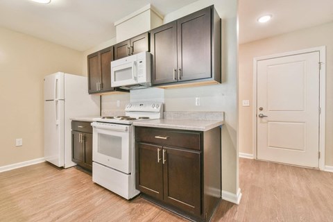 a kitchen with white appliances and dark cabinets
