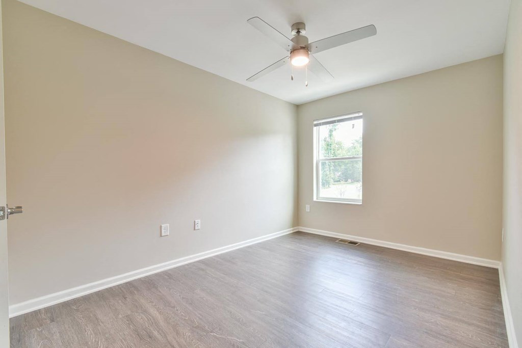 a bedroom with hardwood floors and a ceiling fan