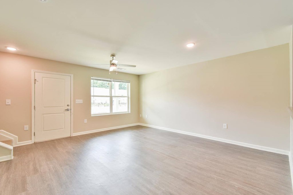 an empty room with a ceiling fan and a window