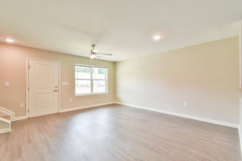an empty room with a ceiling fan and a window