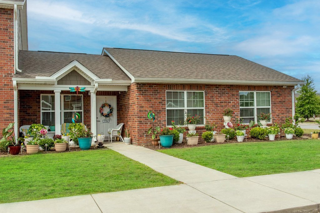 a house with a lawn and potted plants in front of it