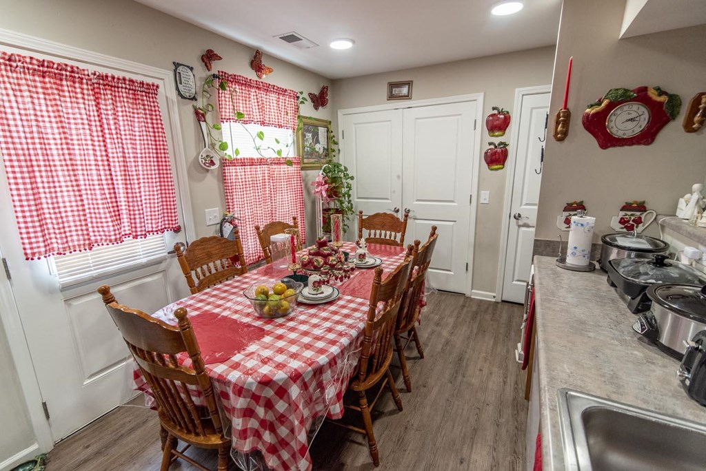 a kitchen with a table and chairs with a red and white checkered tablecloth