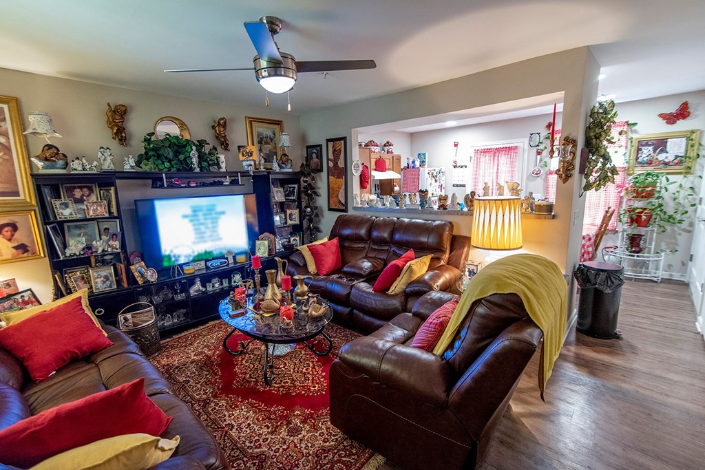 a living room filled with leather furniture and a flat screen tv