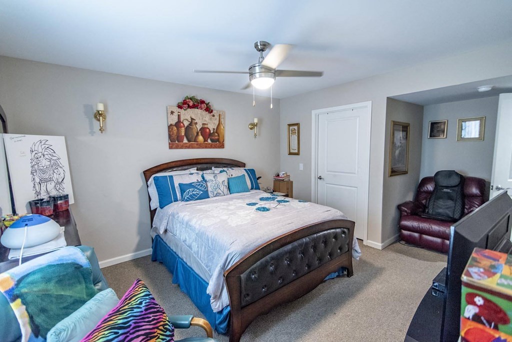 a bedroom with a bed and a ceiling fan
