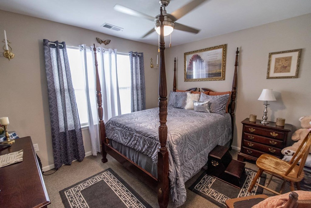 a bedroom with a bed and a ceiling fan