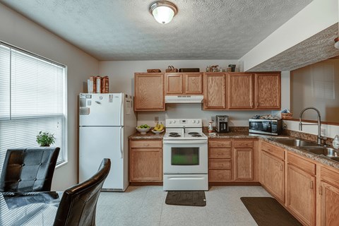 A kitchen with wooden cabinets and a white refrigerator.