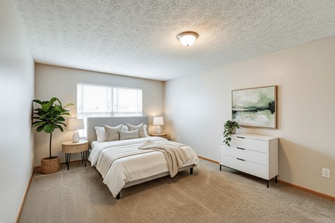 A bedroom with a large bed and a painting on the wall.