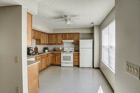 A kitchen with wooden cabinets and white appliances.