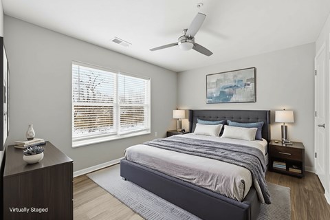 A bedroom with a large bed and a ceiling fan.