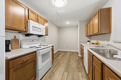 A kitchen with wooden cabinets and white appliances.