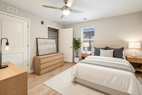 A bedroom with a large bed and a ceiling fan.