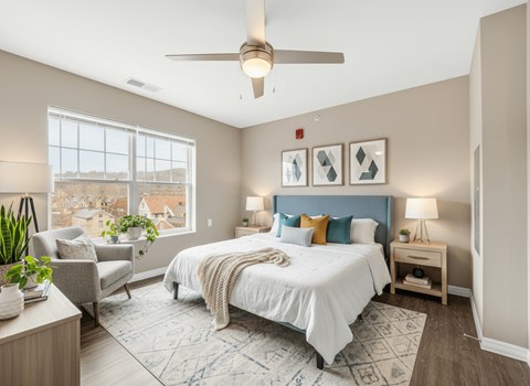 A bedroom with a large bed and a ceiling fan.
