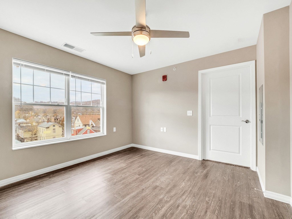 an empty room with a ceiling fan and a window