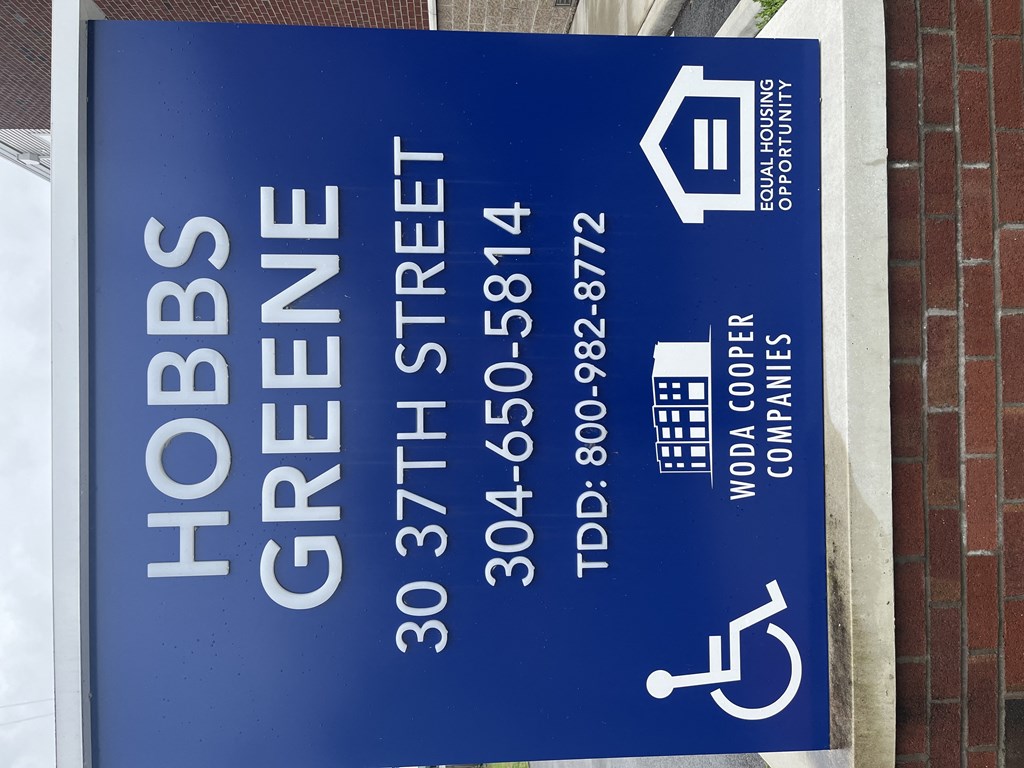 a blue sign with white letters on a brick building