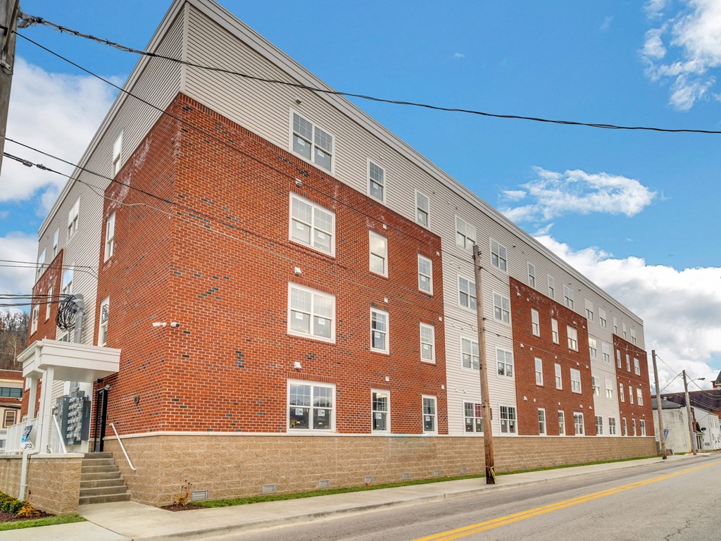 a red brick apartment building on the corner of a street