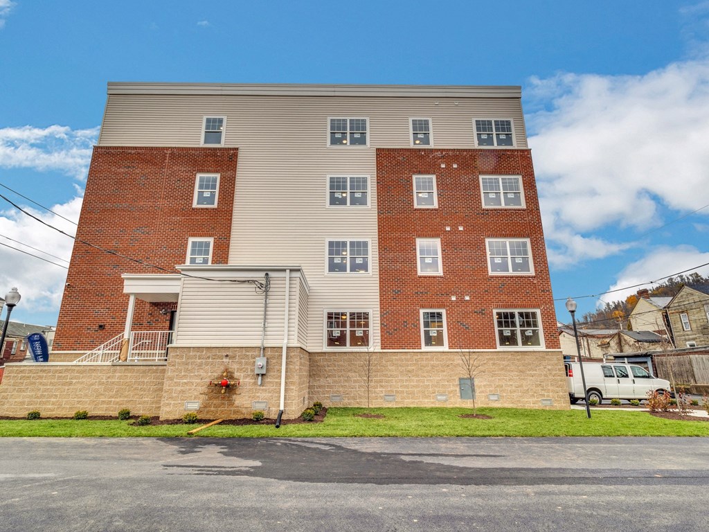 an apartment building with a brick facade and white siding