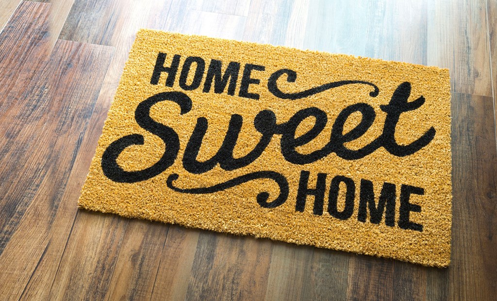 A doormat with the words "Home Sweet Home" written on it.