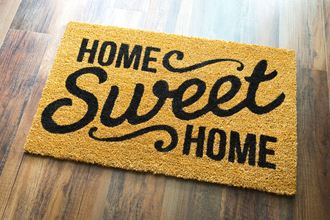 a home sweet home door mat on a wood floor