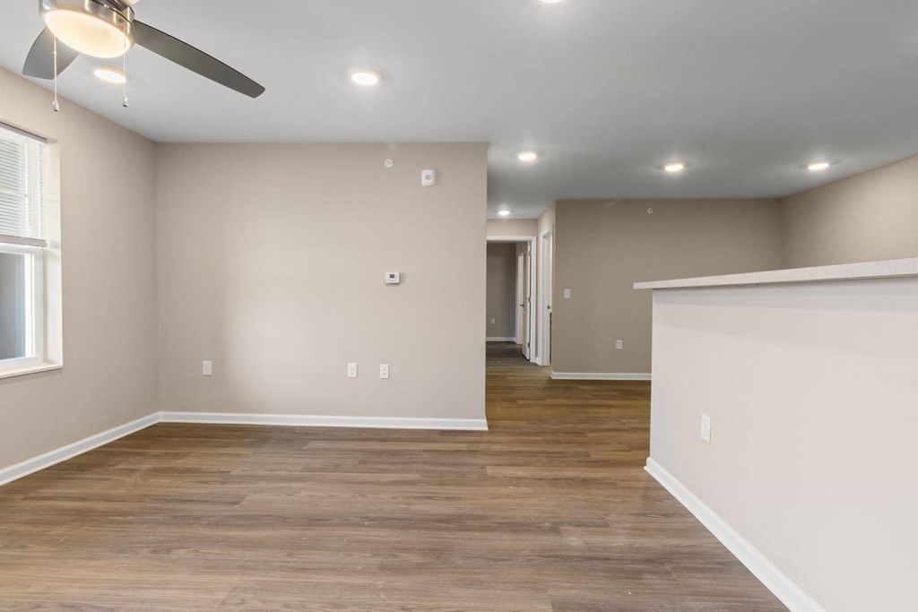 A room with a ceiling fan and wooden flooring.