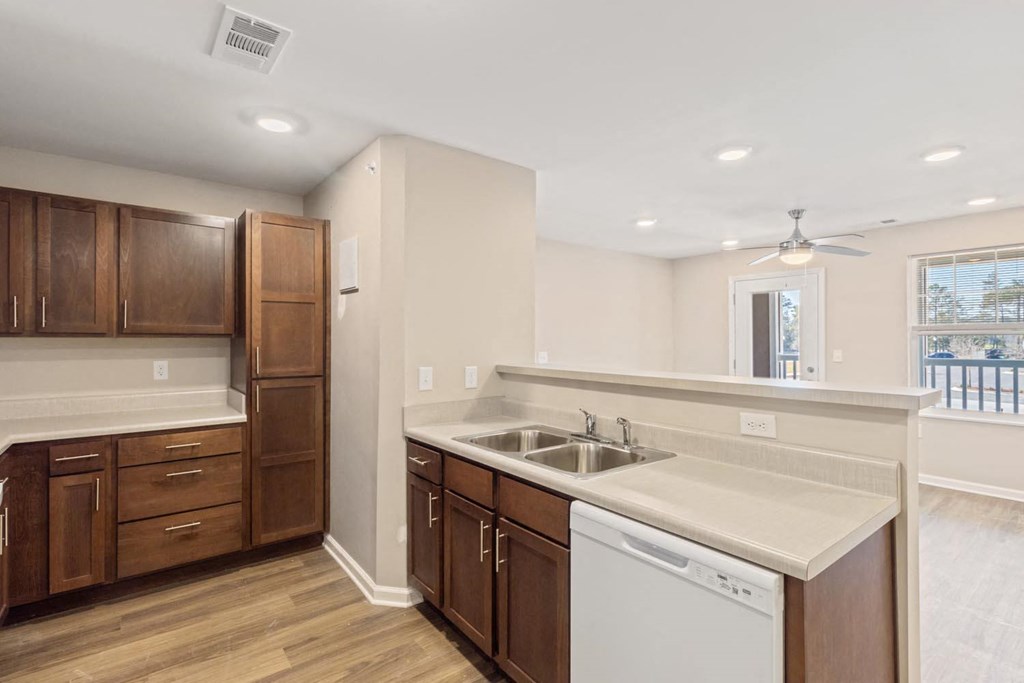 A kitchen with wooden cabinets and a white dishwasher.
