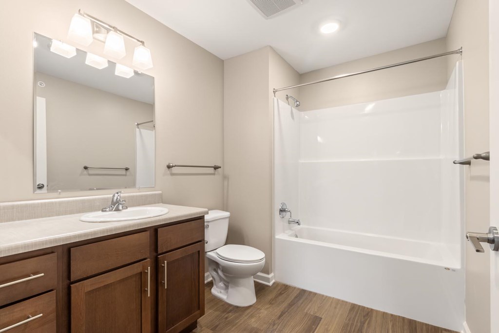 A bathroom with a white tub, sink, and toilet.