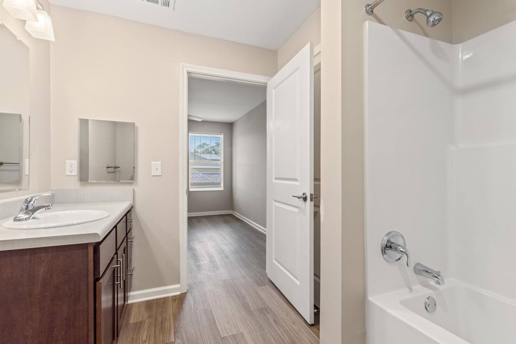 A bathroom with a white tub and a white sink.