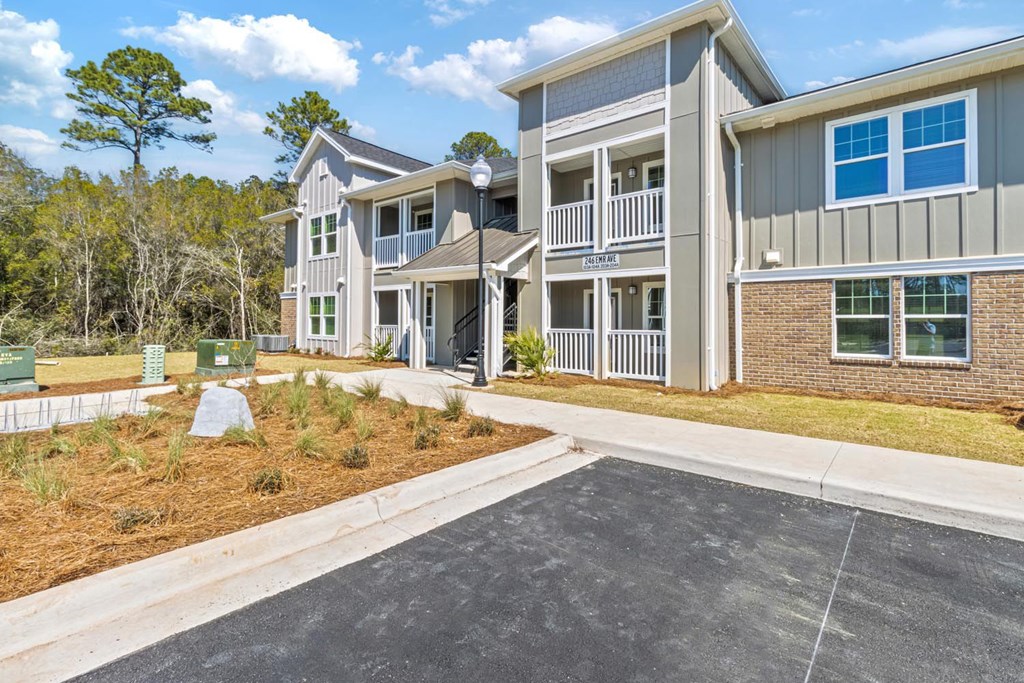A modern two-story building with a parking lot in front.