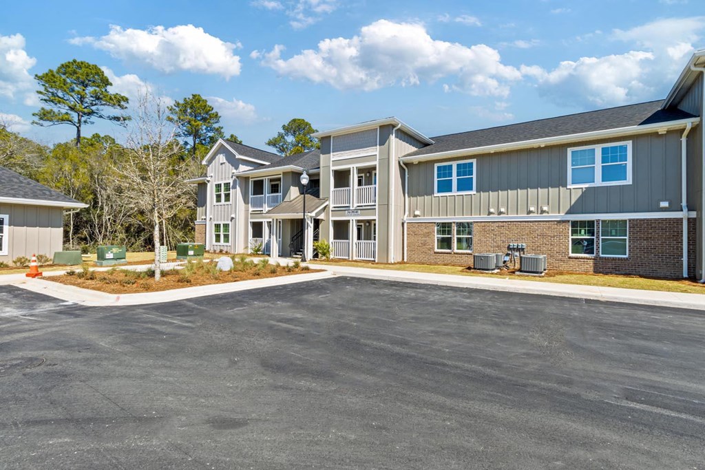 A large, modern building with a parking lot in front.