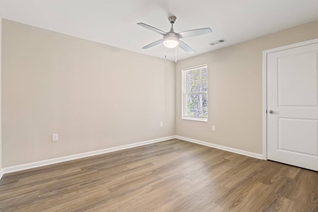 A room with a ceiling fan and a door.