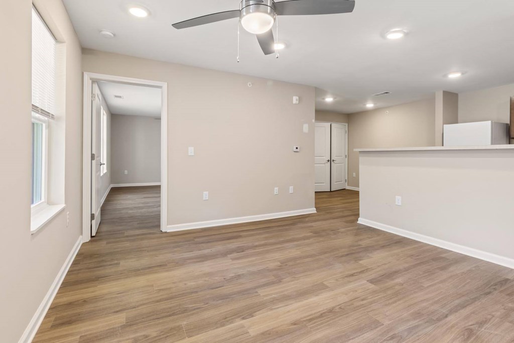 A room with a ceiling fan and wooden flooring.