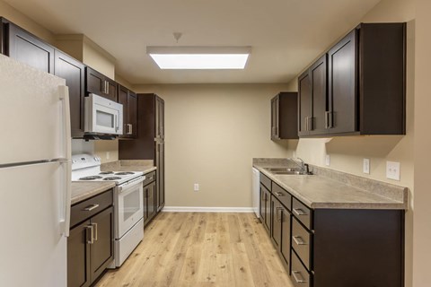 A kitchen with brown cabinets and a white fridge.