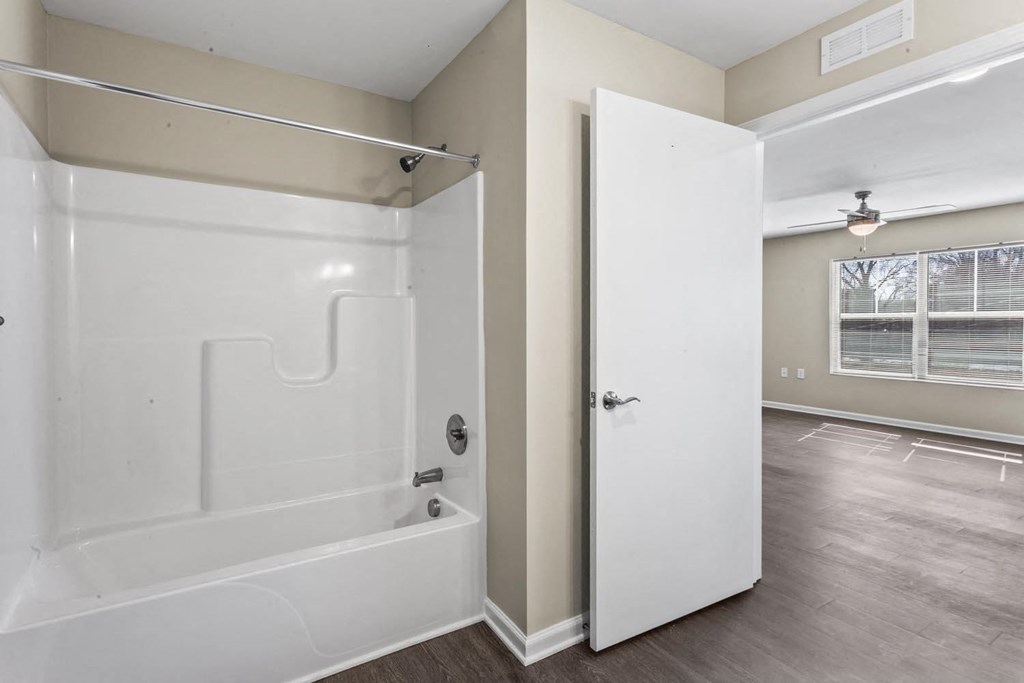 a white bathroom with a tub and a shower
