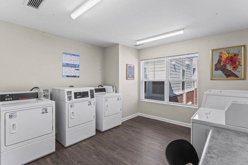 a laundry room with washes and dryers and a window