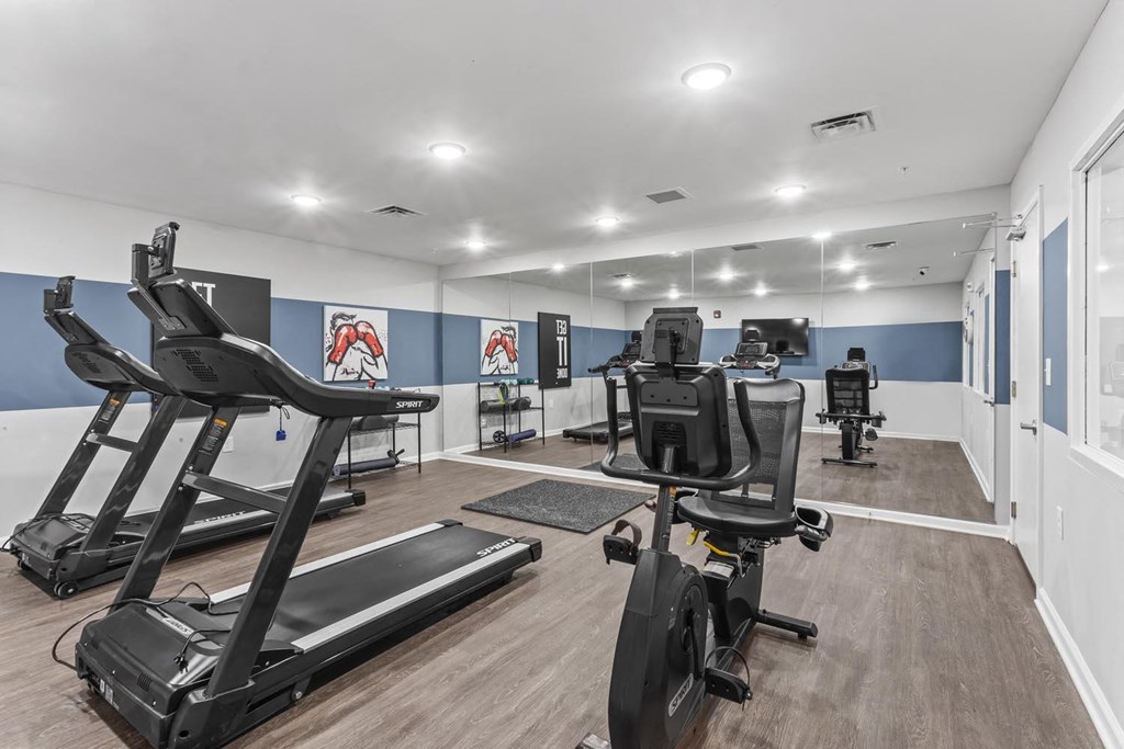 a gym with treadmills and other exercise equipment in a large room with windows