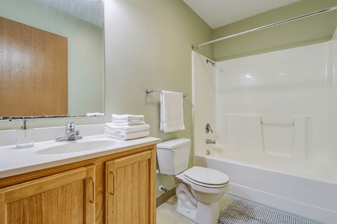 A bathroom with a toilet, sink, and bathtub.