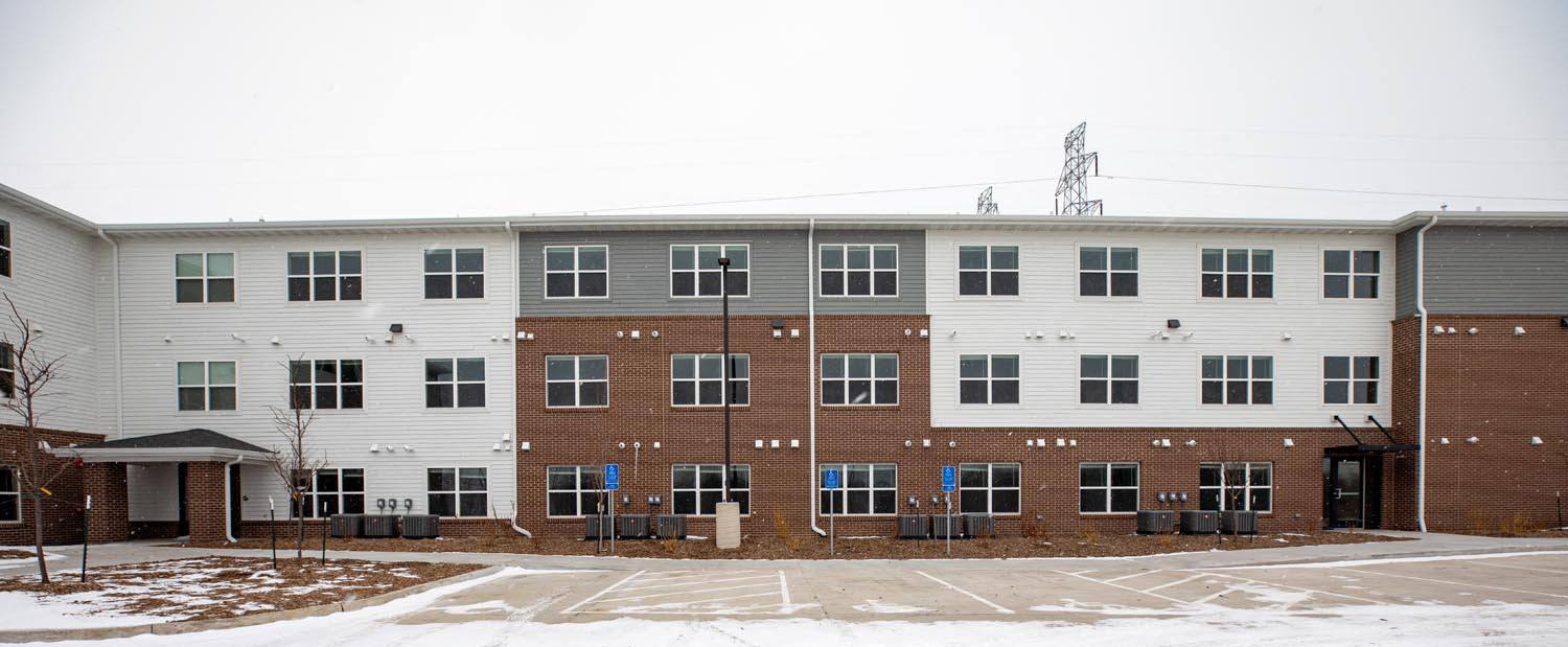 a large brick and white building with snow on the ground