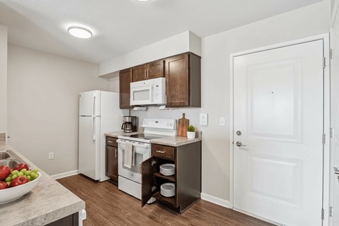 A kitchen with white appliances and a white door.